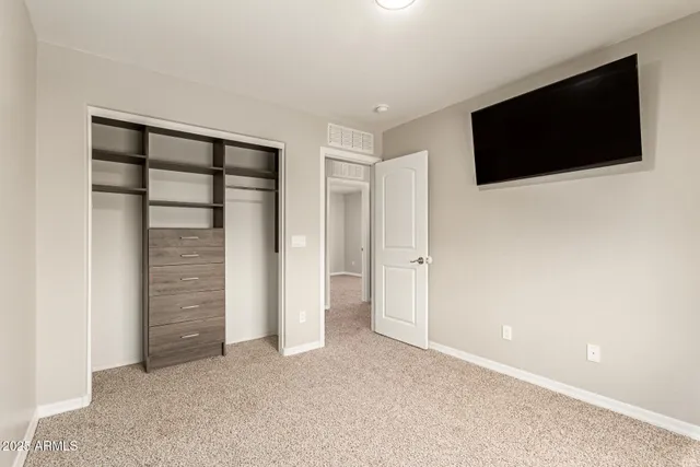 a view of an empty room with tv and a window