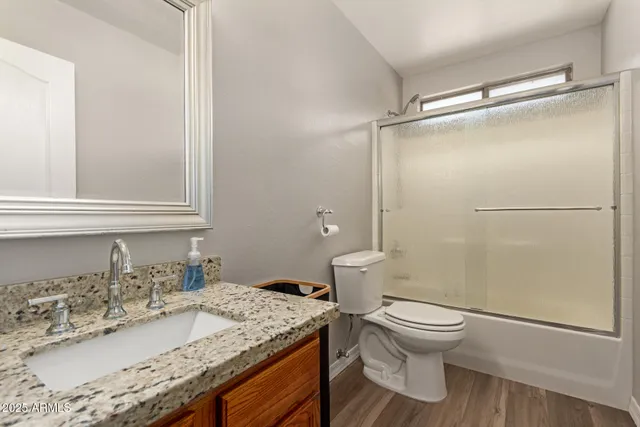 a bathroom with a granite countertop sink toilet and shower