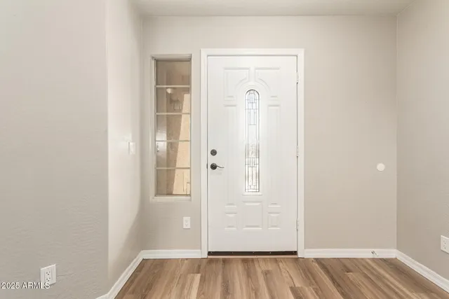 an empty room with wooden floor and mirror