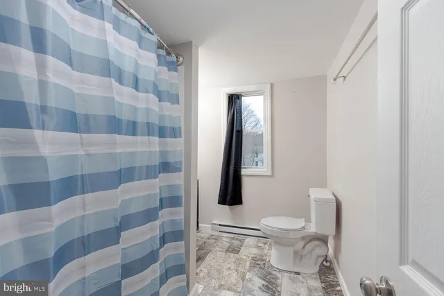 a bathroom with a toilet and a shower