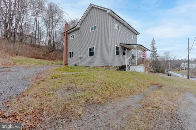 a view of a house with backyard and trees