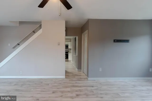 a view of empty room with wooden floor