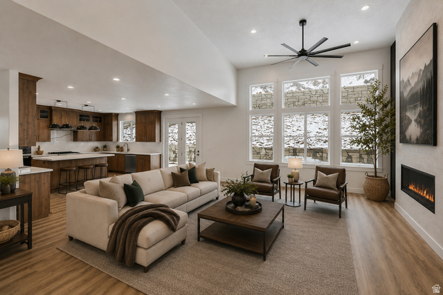 728 East Mountain Road North Ogden, UT 84414 - Photo 6 of 28 Open-concept living space featuring wood-finish flooring, a contemporary fireplace, and a large multi-pane window array