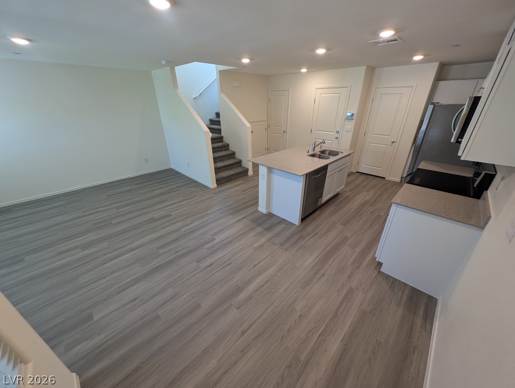 4820 Orchid Rdg Avenue Las Vegas, NV 89141 - Photo 6 of 27 Discover a spacious open-concept living area with durable plank flooring, flowing seamlessly into a modern kitchen.