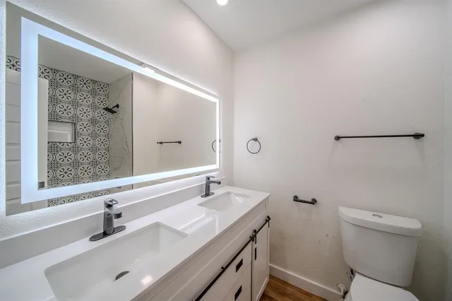 a bathroom with a sink a toilet and shower