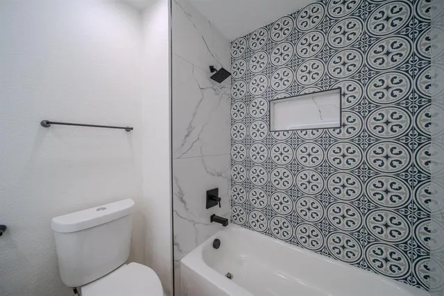 a bathroom with a toilet and a shower