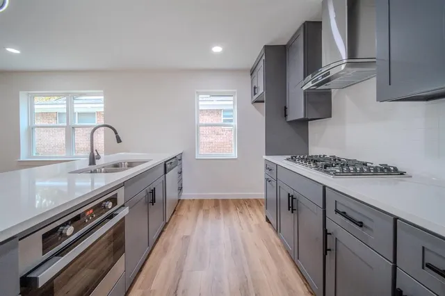 a kitchen with stainless steel appliances a sink dishwasher stove and oven