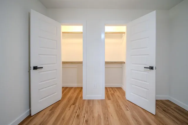 a view of walk in closet with wooden floor