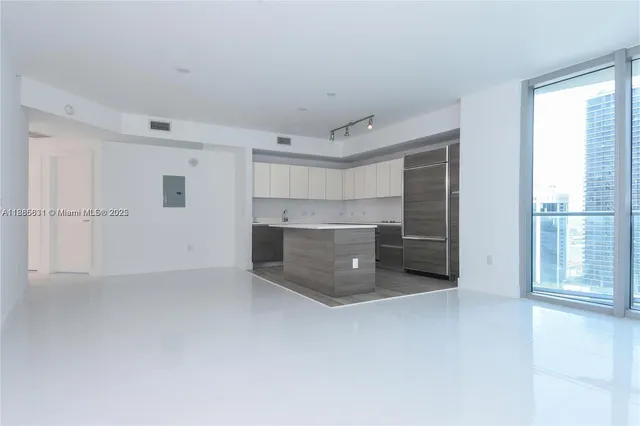 a view of a kitchen with a sink and an empty room