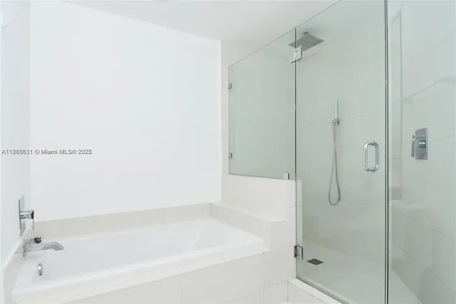 a white bath tub sitting next to a shower
