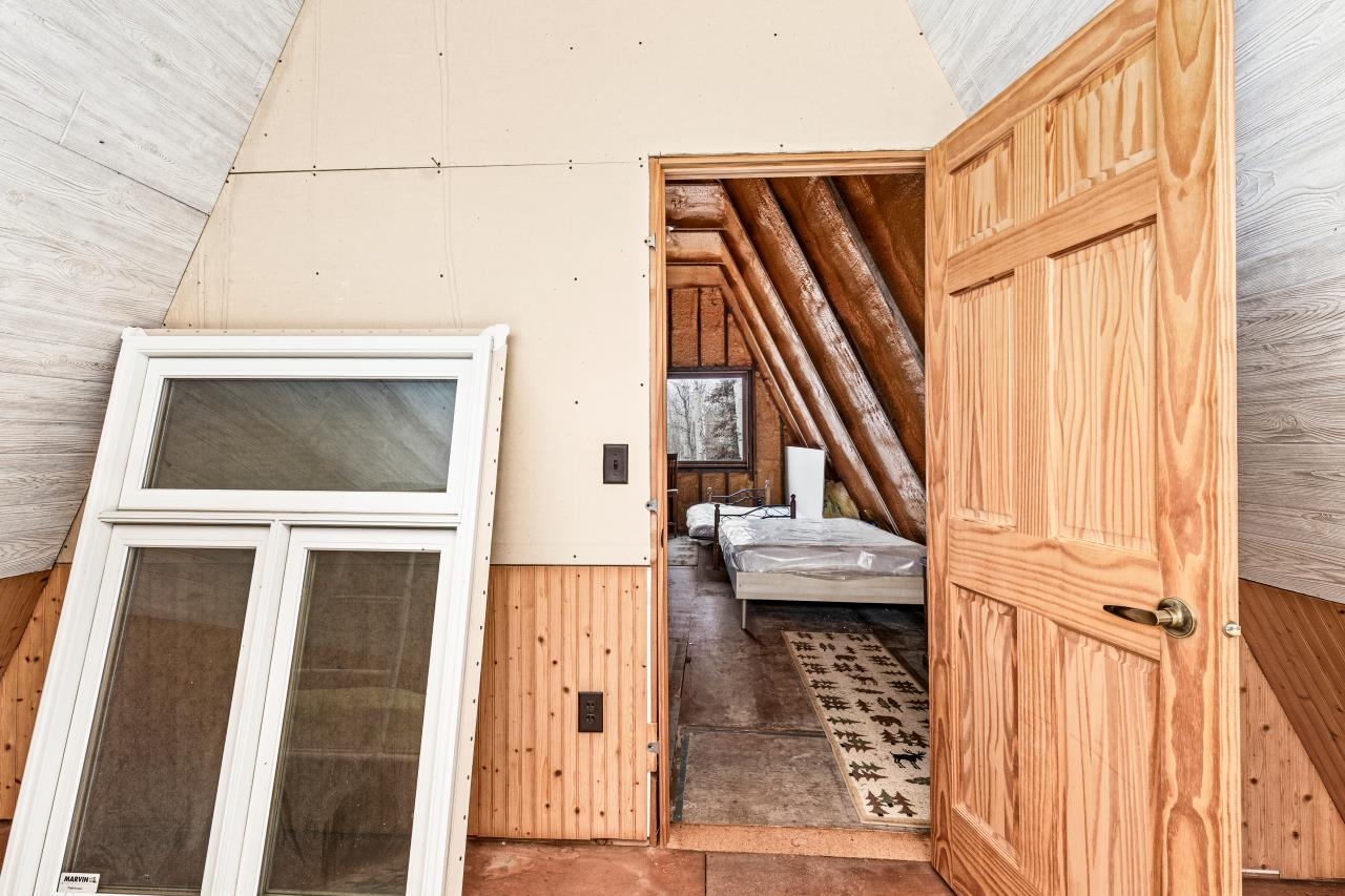 2040 Green Acres Road Maple, WI 54854 - Photo 17 of 19 Unfurnished bedroom with wood walls, vaulted ceiling, and wainscoting