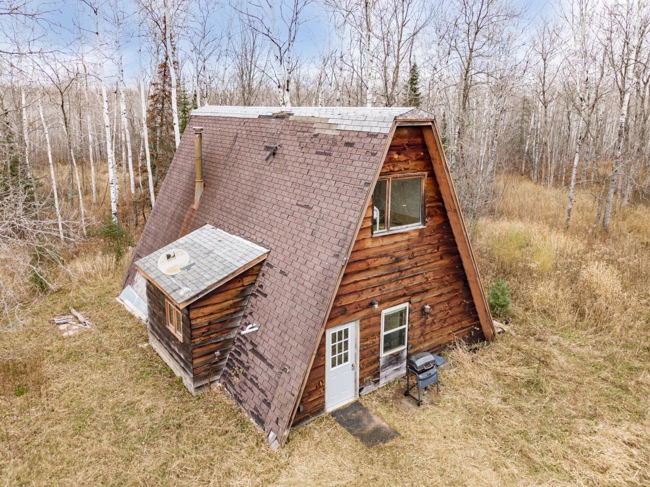 2040 Green Acres Road Maple, WI 54854 - Photo 19 of 19 View of property exterior featuring a shingled roof and a wooded view