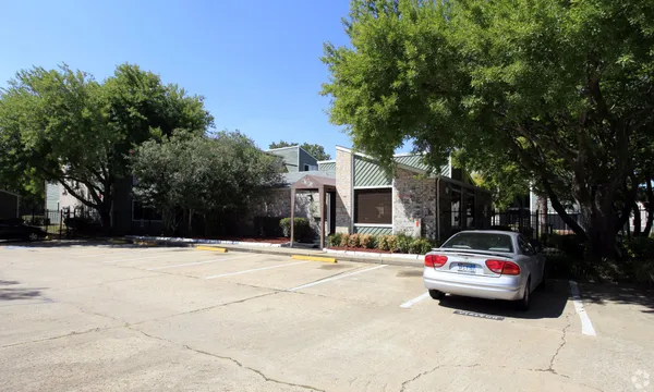 a car parked in front of house with trees