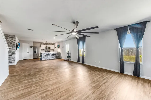 a view of empty room with wooden floor and window
