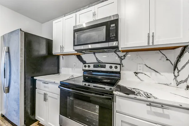 a kitchen with cabinets and steel stainless steel appliances
