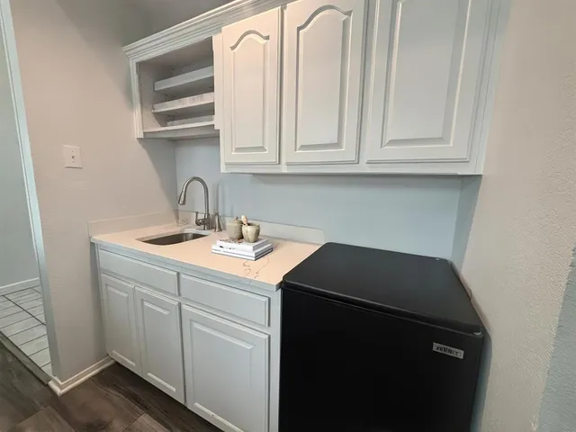 a utility room with sink dryer and cabinets