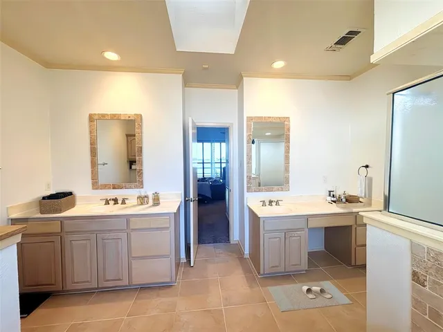 a view of a double vanity sink mirror and window