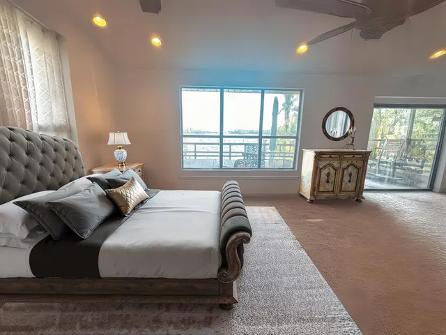 a bedroom with a bed and a large window