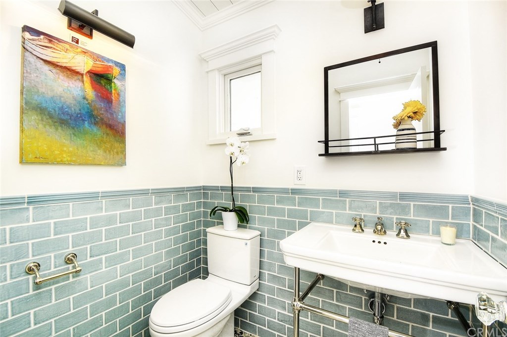 564 Oak Street Laguna Beach, CA 92651 - Photo 13 of 34 Powder room behind the swinging door boasts stunning handmade floor tile and handmade glass tile backsplash.