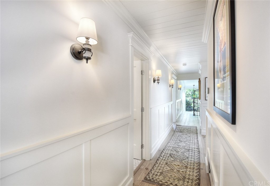 564 Oak Street Laguna Beach, CA 92651 - Photo 14 of 34 Hallway with designer lighting and wainscoting leads from the living area to 4 bedrooms and a downstairs bonus room or 5th bedroom.