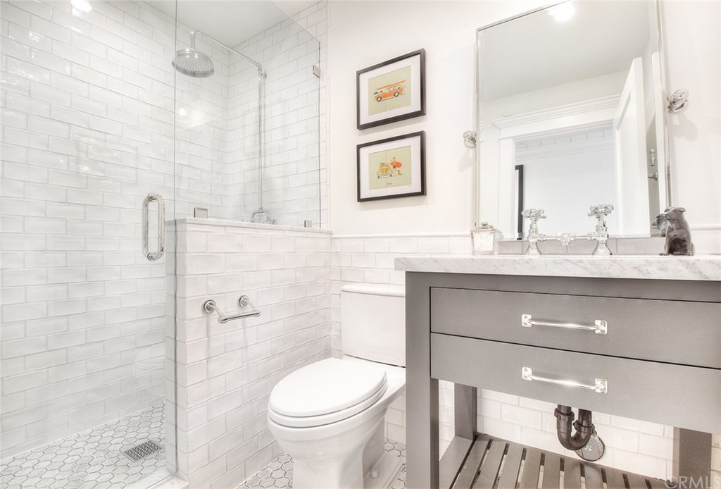564 Oak Street Laguna Beach, CA 92651 - Photo 20 of 34 Beautiful hall bath with Carrara mosaic flooring and walk-in shower with custom glass shower enclosure