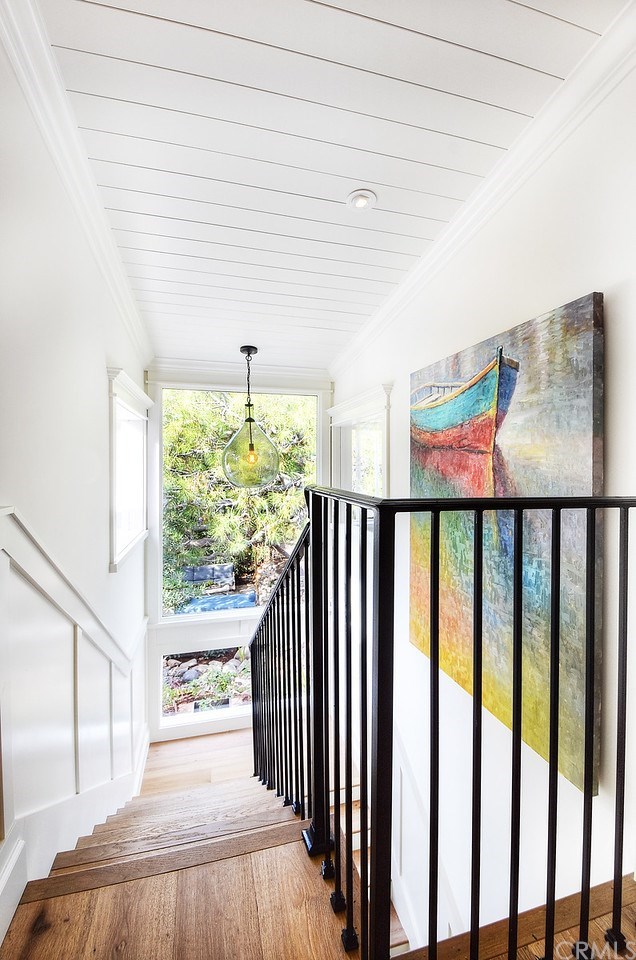 564 Oak Street Laguna Beach, CA 92651 - Photo 23 of 34 Staircase with stunning designer light fixture and a wall of windows leads downstairs to a bonus room or 5th bedroom.