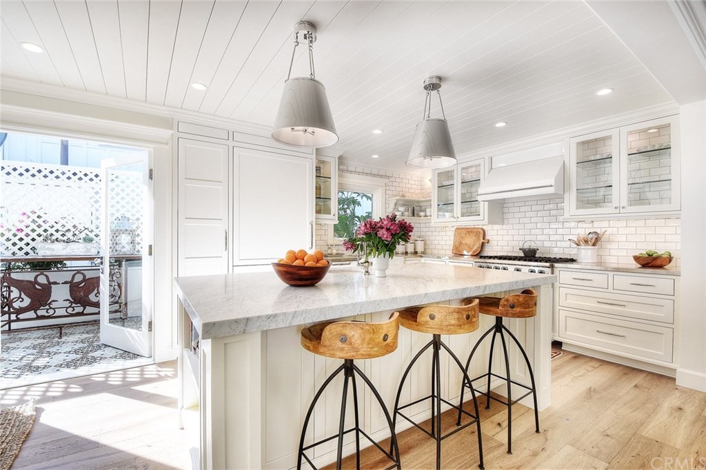 564 Oak Street Laguna Beach, CA 92651 - Photo 5 of 34 Stunning kitchen with slab Carrara marble island with prep sink, designer lighting, high-grade appliance package (Sub Zero, Viking, Bosch), and stainless steel counters.