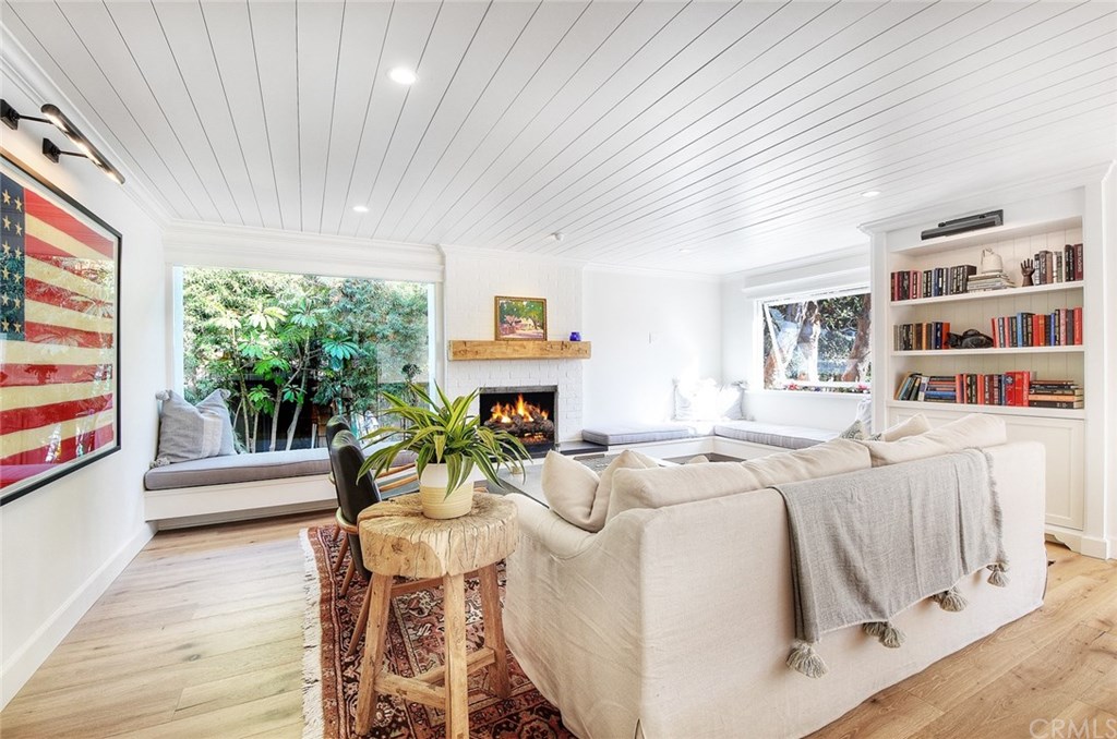 564 Oak Street Laguna Beach, CA 92651 - Photo 10 of 34 Family room with picture windows, built-in seating with custom cushions, and intimate wood burning and gas fireplace with reclaimed wood beam mantle.