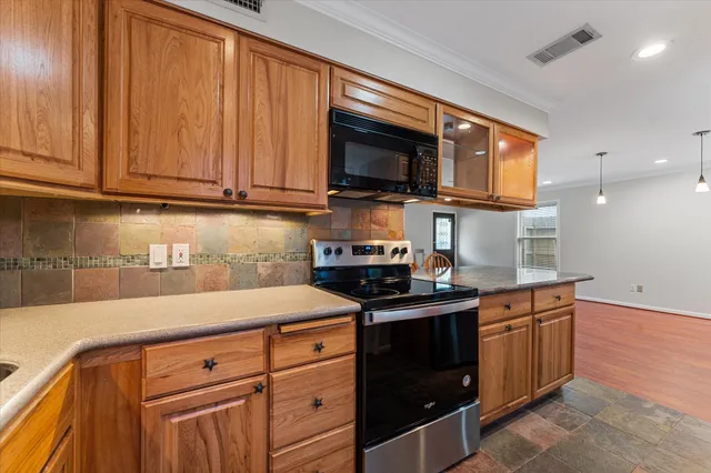 a kitchen with stainless steel appliances granite countertop a sink stove and microwave