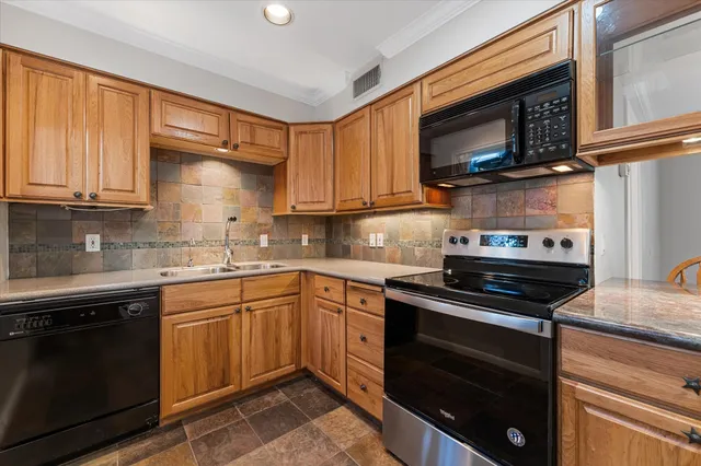 a kitchen with stainless steel appliances granite countertop a stove microwave and sink