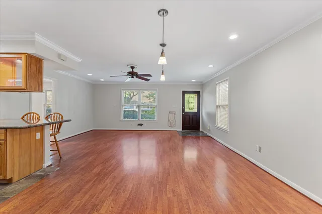 a view of an empty room with window and wooden floor