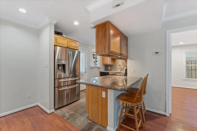 a kitchen with stainless steel appliances granite countertop a refrigerator and a stove top oven
