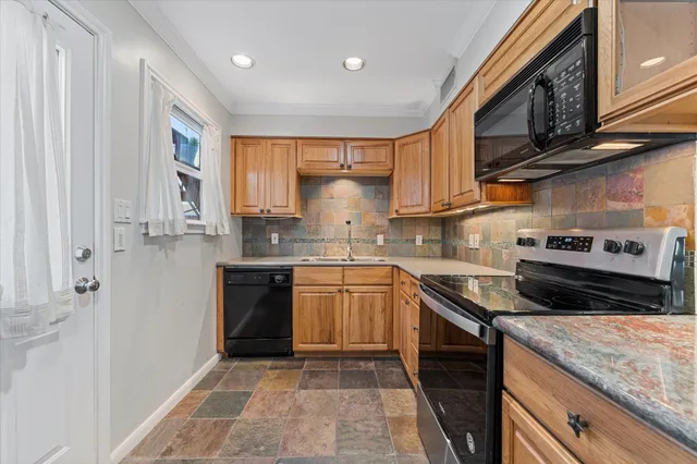a kitchen with stainless steel appliances granite countertop a stove sink and cabinets