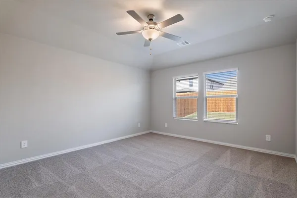 an empty room with a window and a ceiling fan