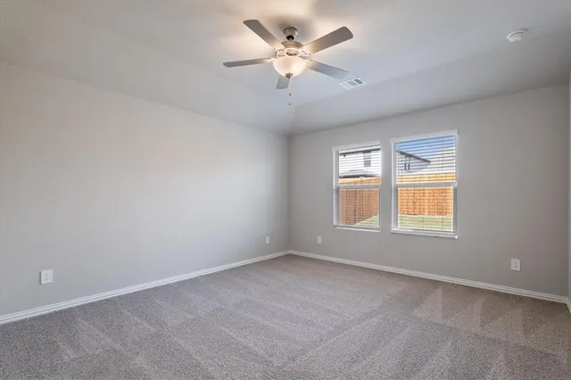 an empty room with a window and a ceiling fan