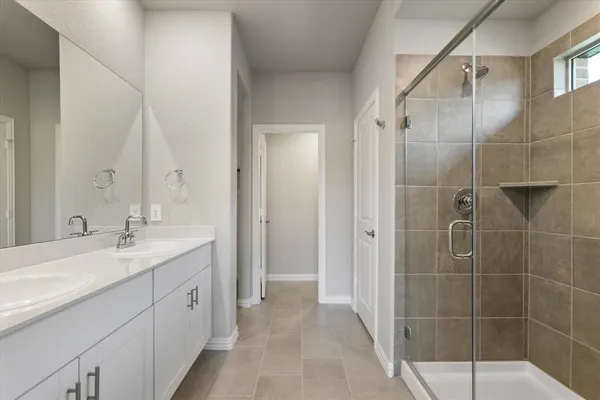 a spacious bathroom with a shower sink and mirror