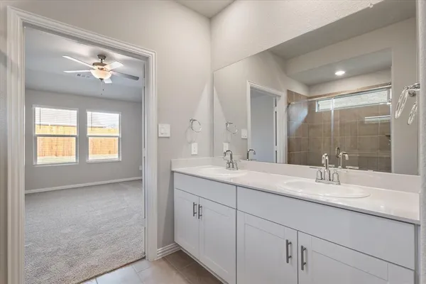 a en suite bathroom with double vanity a sink and a mirror