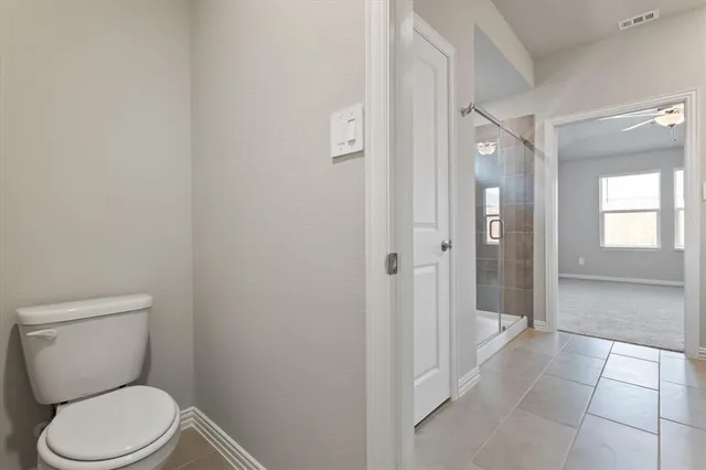 a bathroom with a toilet and a shower