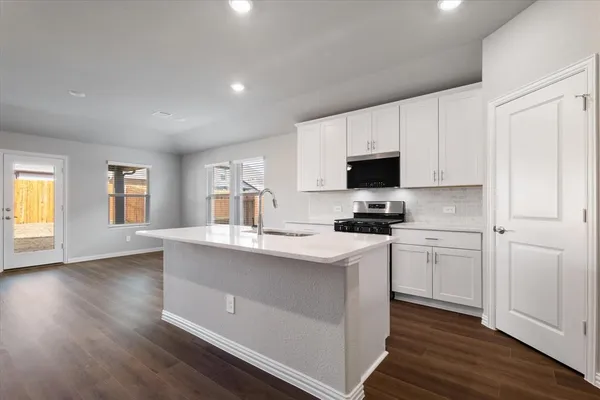 a kitchen with a sink stove and cabinets