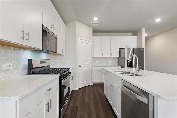 a kitchen with stainless steel appliances a sink stove and cabinets