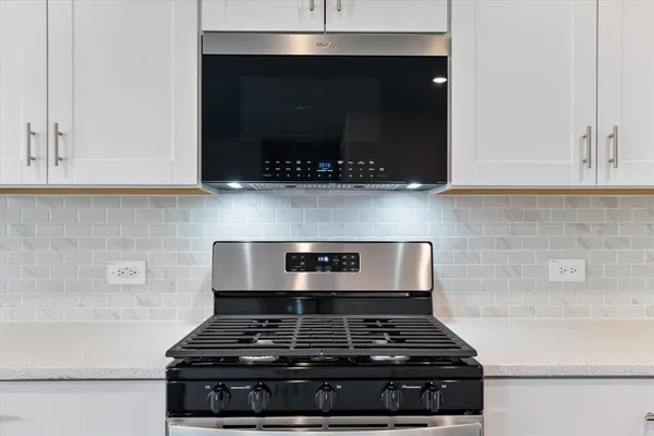 a stove top oven sitting inside of a kitchen