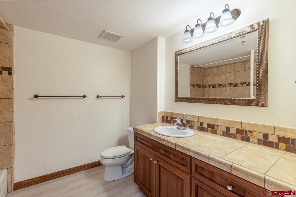355 East 3rd Avenue, Unit 112 Durango, CO 81301 - Photo 11 of 27 a bathroom with a granite countertop sink a toilet and a mirror