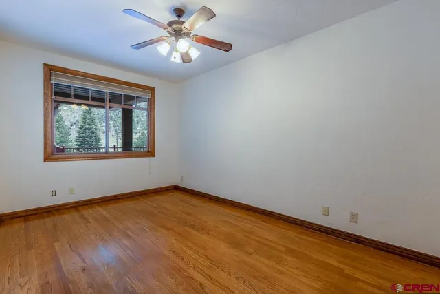 an empty room with a window and a fan