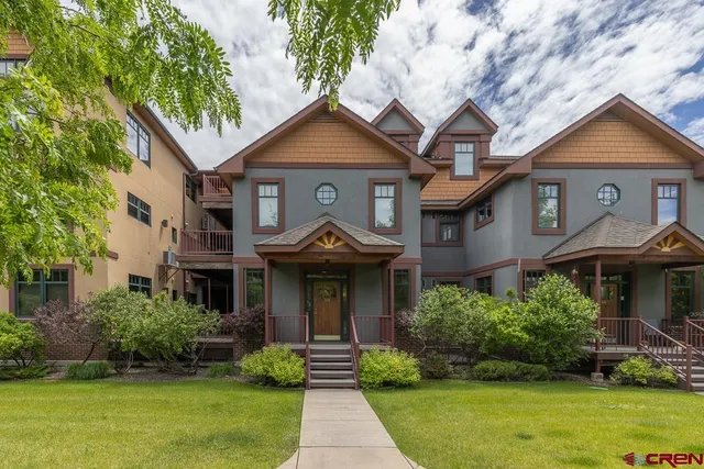 a front view of a house with a yard and trees