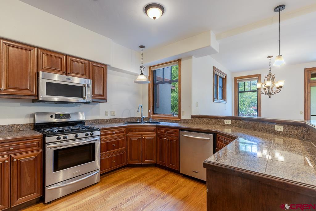 355 East 3rd Avenue, Unit 112 Durango, CO 81301 - Photo 7 of 27 a kitchen with stainless steel appliances granite countertop a stove a sink and a microwave