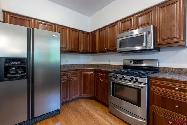 a kitchen with stainless steel appliances granite countertop a refrigerator stove and microwave