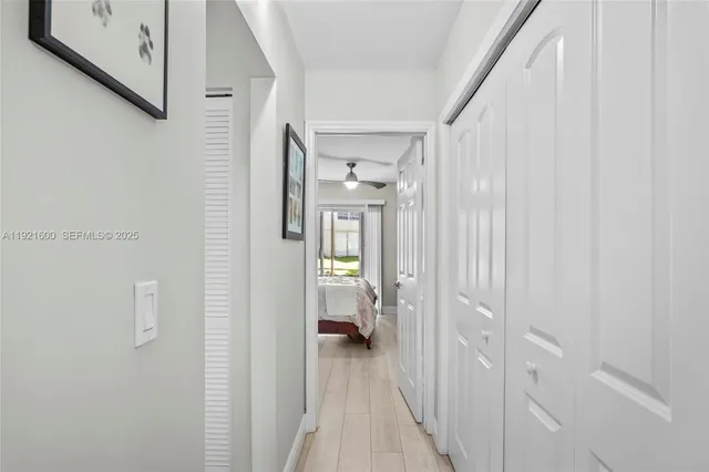 a view of a hallway with bathroom and wooden floor