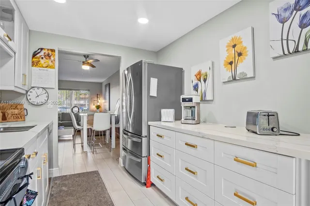 a kitchen with stainless steel appliances granite countertop a dining table and chairs