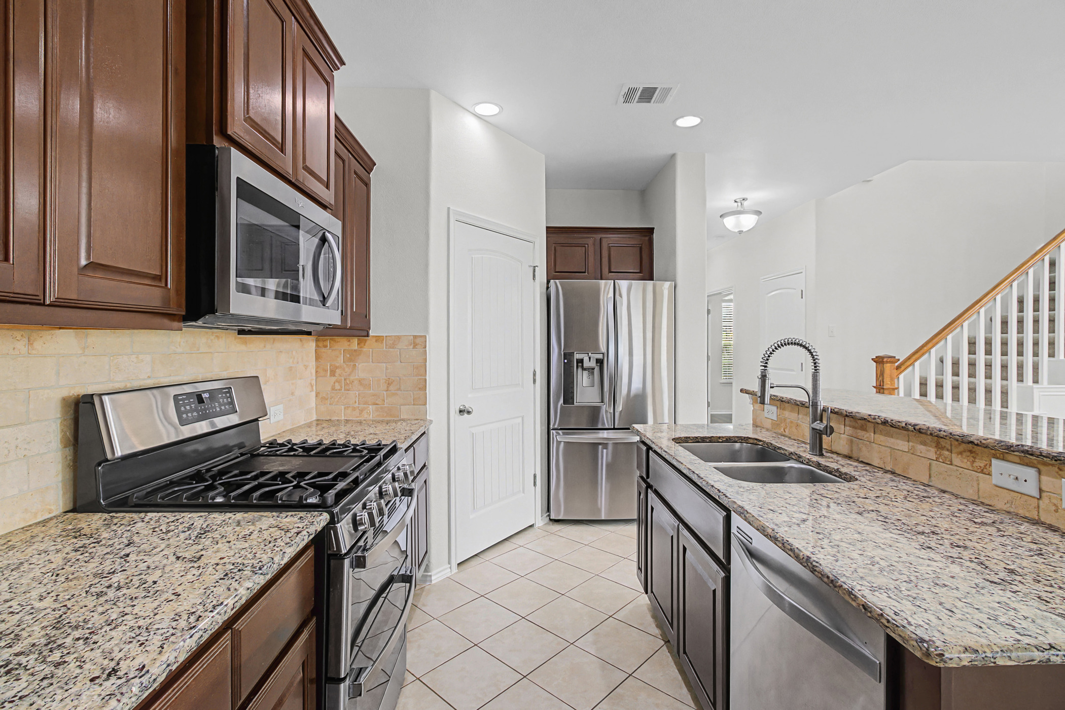 501 Silver Trail Round Rock, TX 78664 - Photo 3 of 22 a kitchen with stainless steel appliances granite countertop a sink stove and refrigerator