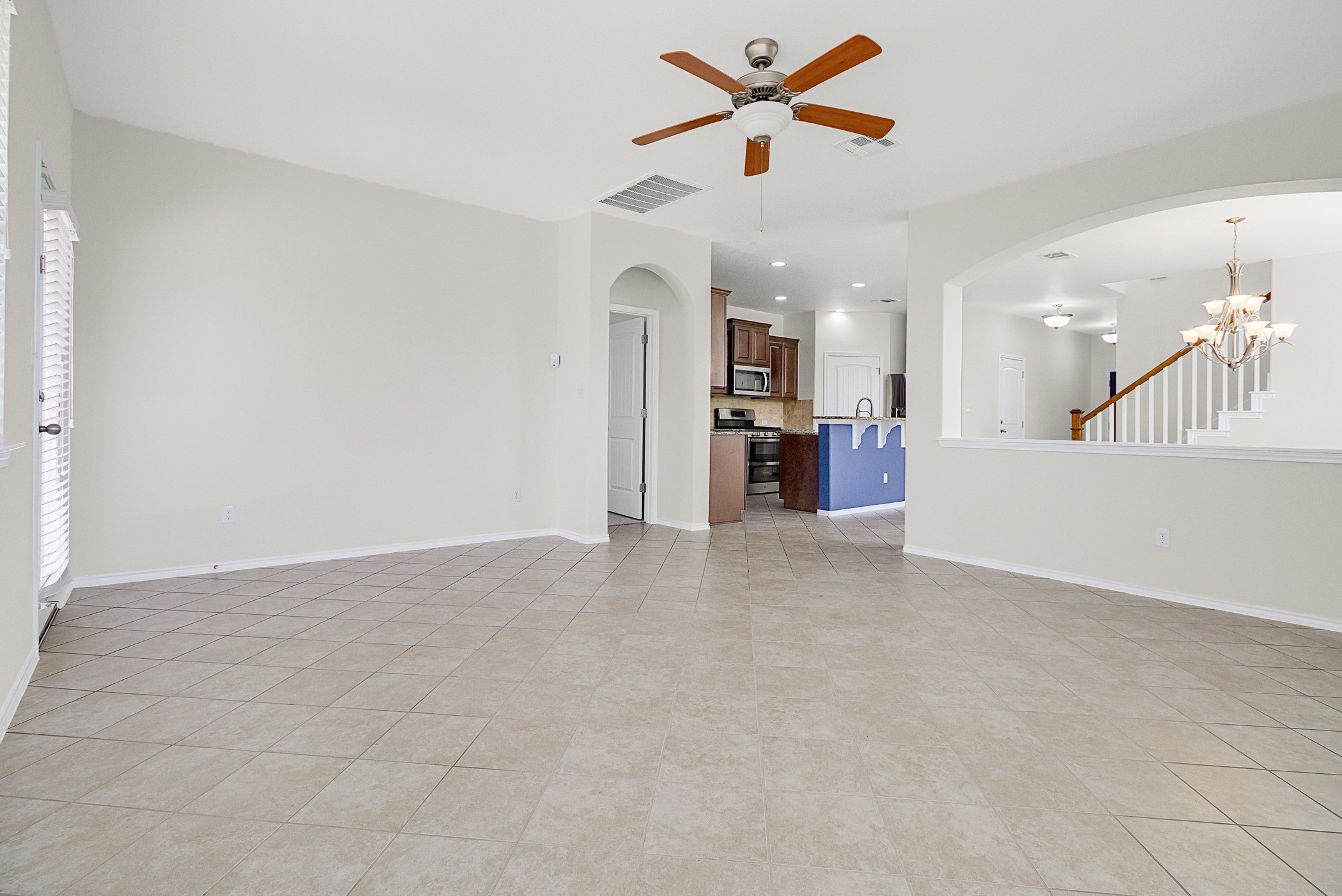 501 Silver Trail Round Rock, TX 78664 - Photo 8 of 22 an empty room with a kitchen and a ceiling fan